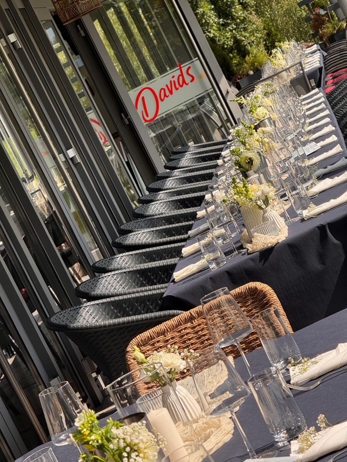 Festlich eingedeckte lange Tafel auf der Terrasse für eine Feier