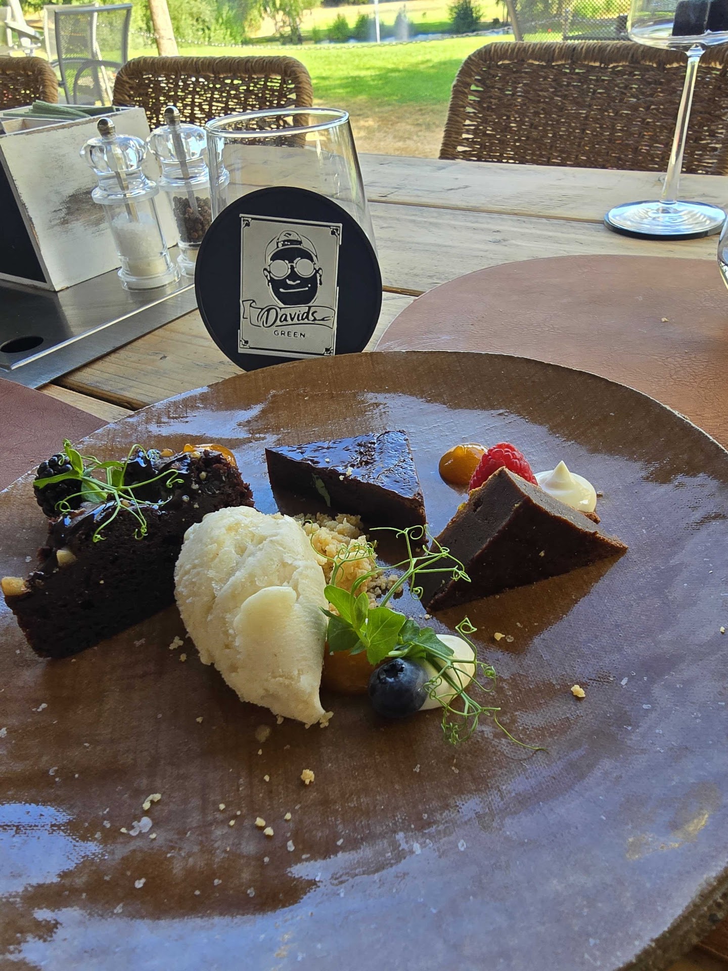 Schokoladen-Dessert mit Eis und Beeren, dahinter ein Davids.green-Untersetzer